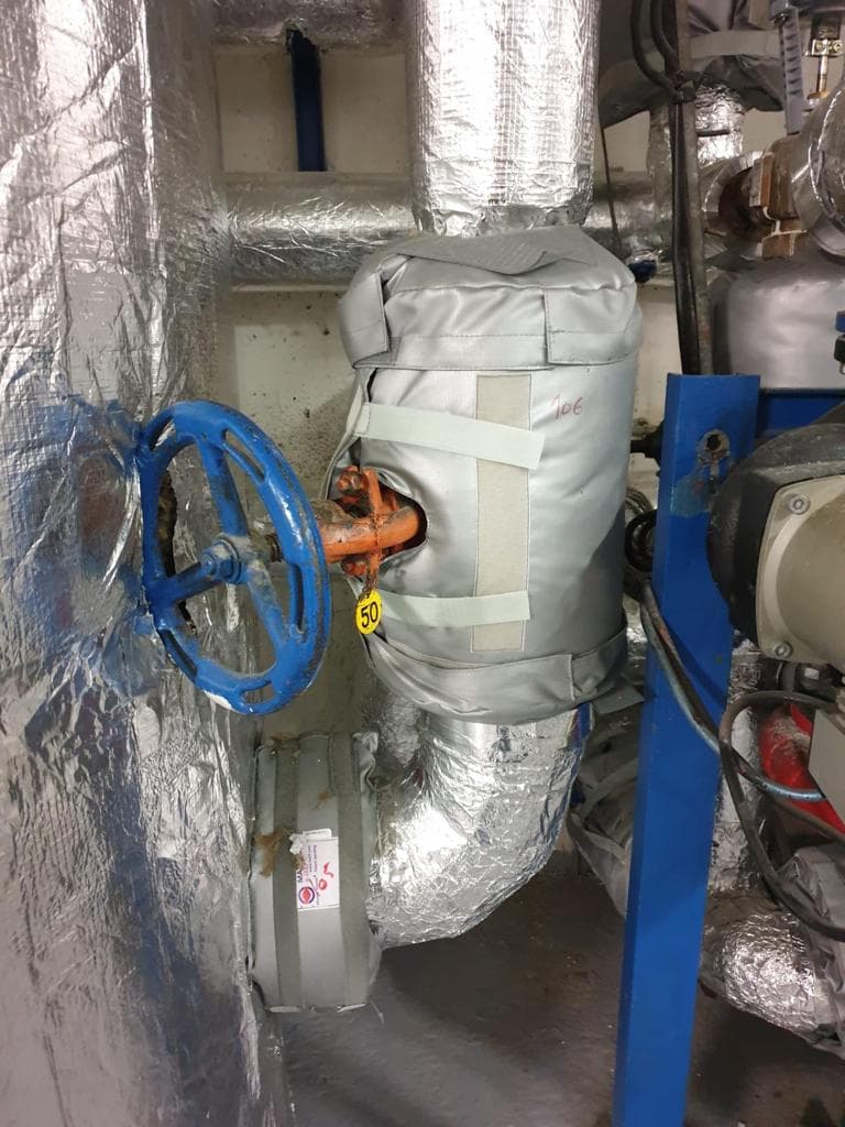 Housse isolante démontable posée sur une vanne de chaufferie collective